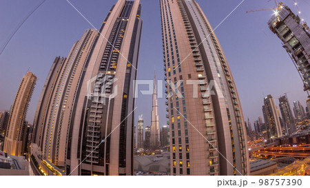Tallest skyscrapers in downtown dubai located on bouleward street near shopping mall aerial night to day . Tallest skyscrapers in downtown dubai located on bouleward street near shopping mall aerial night to day . 98757390