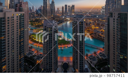 Dubai Downtown cityscape with tallest skyscrapers around aerial night to day . 98757411