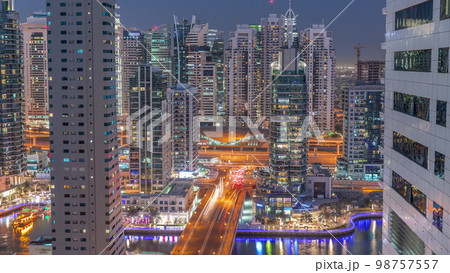 Aerial view on Dubai Marina skyscrapers and the most luxury yacht in harbor day to night , Dubai, United Arab Emirates 98757557