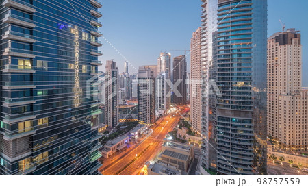View of the Dubai Marina and JBR area and the famous Ferris Wheel aerial night to day 98757559