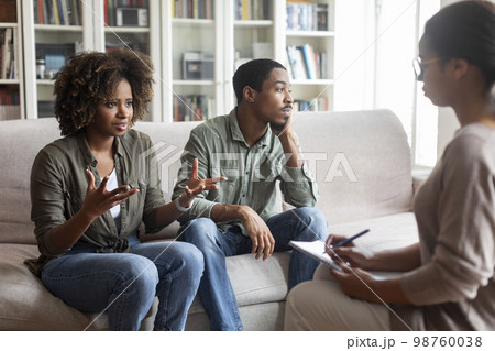 Young black woman sharing thoughts with psychologist during family session Young black woman sharing thoughts with psychologist during family session 98760038