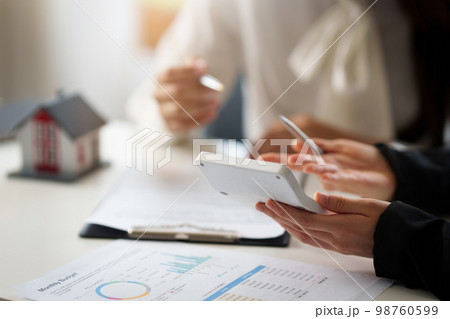 Banker or Agent calculate price for buy or loan house and showing to customer. Real Estate concept. Banker or Agent calculate price for buy or loan house and showing to customer. Real Estate concept. 98760599