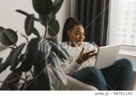 African american woman making video call in living room - social networks and connection 98761192