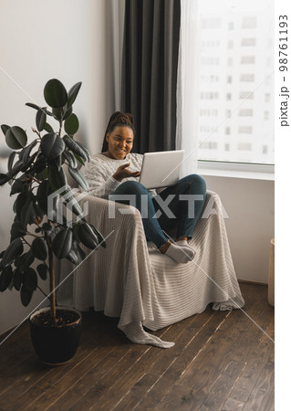African american woman making video call in living room - social networks and connection 98761193