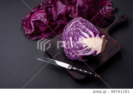 Fresh beautiful red cabbage with textured leaves on a dark concrete background Fresh beautiful red cabbage with textured leaves on a dark concrete background 98761281