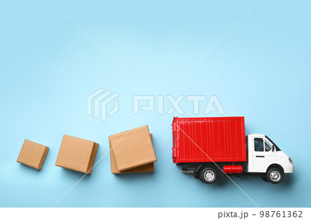 Top view of toy truck with boxes on blue background. Logistics and wholesale concept Top view of toy truck with boxes on blue background. Logistics and wholesale concept 98761362