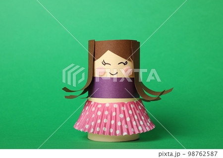 Toy doll made of toilet paper hub on green background 98762587