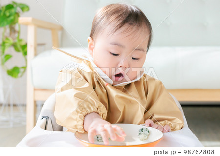 離乳食を手づかみ食べするカミカミ期の赤ちゃん 98762808