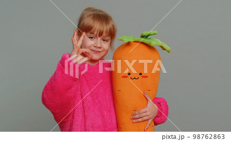Young toddler school girl in sweater looking approvingly at camera showing okey gesture, like sign Young toddler school girl in sweater looking approvingly at camera showing okey gesture, like sign 98762863