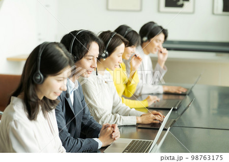 ヘッドセットをつけて働く人々 ヘッドセットをつけて働く人々 98763175