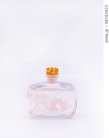Wooden aroma sticks in a glass flask filled with flavor liquid substance isolated over white background, side view Wooden aroma sticks in a glass flask filled with flavor liquid substance isolated over white background, side view 98763622