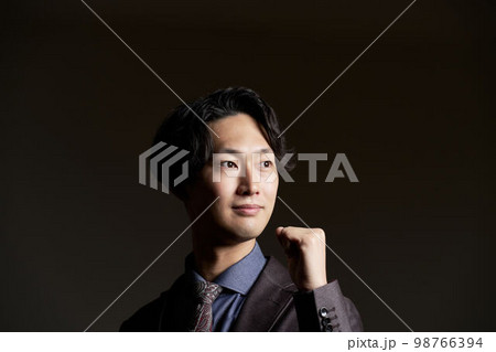 拳を握りながら遠くを見る若いビジネスパーソン 98766394