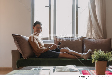 Man working with tablet and relax on the sofa. Concept work and travel. Man working with tablet and relax on the sofa. Concept work and travel. 98767227