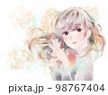 胸の前で手を組む少女/微笑み/イエロー背景 98767404