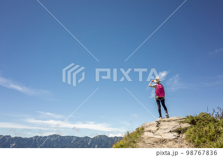 Asian mountain climbing woman pointing at far away Asian mountain climbing woman pointing at far away 98767836