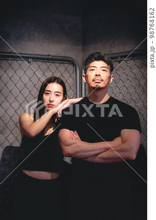 金網の前でポージングする男女 金網の前でポージングする男女 98768162