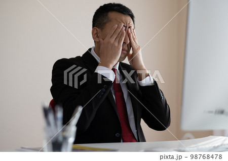 オフィスで眠くなる・疲れたビジネスマン 98768478
