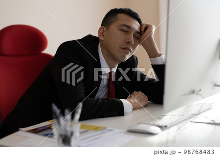 オフィスで眠くなる・疲れたビジネスマン 98768483