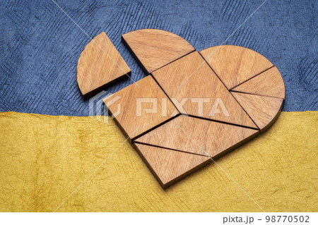 heart tangram against paper abstract in colors of Ukrainian national flag - blue and yellow, support Ukraine concept 98770502
