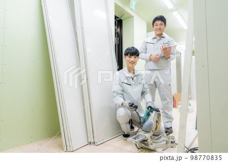工事中のマンションの部屋で作業をする作業服を着た男性2人のポートレート 工事中のマンションの部屋で作業をする作業服を着た男性2人のポートレート 98770835