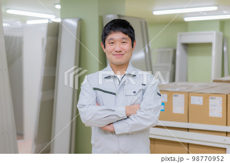 工事中のマンションの部屋に立つ若い作業服を着た男性のポートレート 工事中のマンションの部屋に立つ若い作業服を着た男性のポートレート 98770952