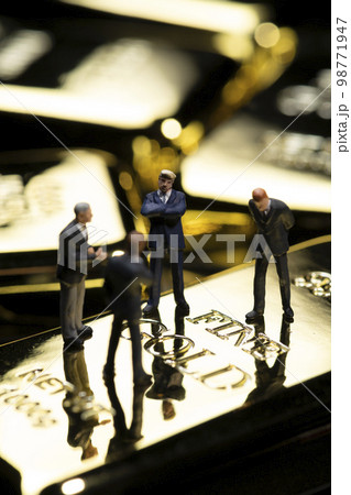ミニチュアのビジネスパーソンと金塊のイメージ 98771947