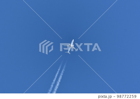 青空を飛ぶジェット機と飛行機雲 98772259