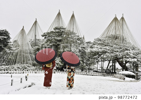雪が舞う兼六園を散策する着物女子 98772472