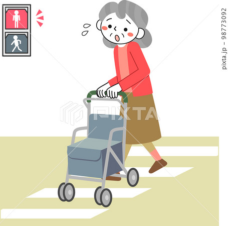 道路を渡り切れず信号が赤になって困っているシニア女性 98773092