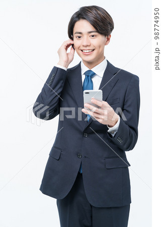 電話をするスーツ姿の若い男性 電話をするスーツ姿の若い男性 98774950