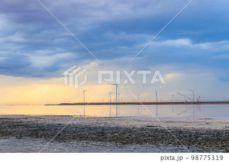 Building and assembling a construction wind turbines farm by a crane Building and assembling a construction wind turbines farm by a crane 98775319