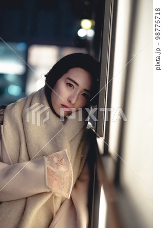 夜の街で切なげな表情の女性 98776718