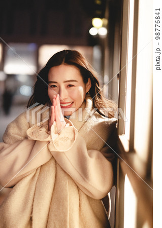 夜の街でデートの待ち合わせ中の女性 98776841