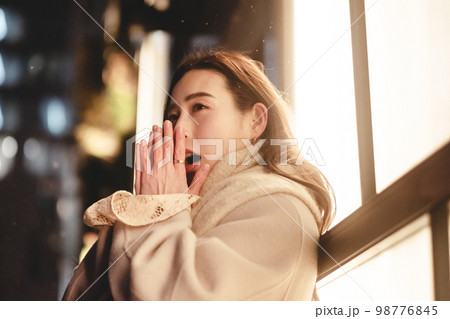 夜の街でデートの待ち合わせ中の女性 98776845