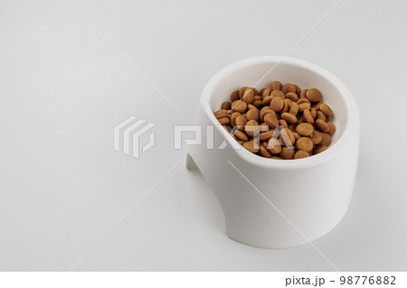 白いペット用食器と粒状のペットフード、白背景 白いペット用食器と粒状のペットフード、白背景 98776882