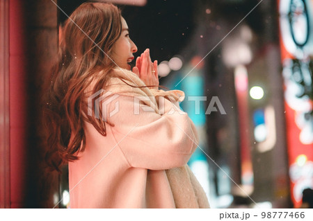 夜の街で寒くて手を温める女性 98777466