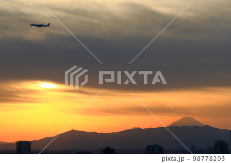commercial plane flying above Mt. Fuji during sunset heading for Haneda Airport as seen from central Tokyo Japan. commercial plane flying above Mt. Fuji during sunset heading for Haneda Airport as seen from central Tokyo Japan. 98778203