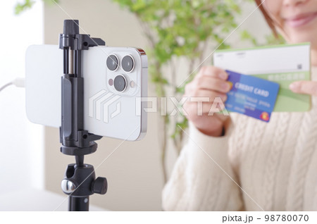 固定されたスマホに向かってしゃべる女性 固定されたスマホに向かってしゃべる女性 98780070