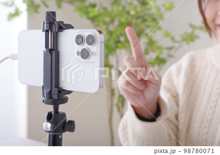固定されたスマホに向かってしゃべる女性 固定されたスマホに向かってしゃべる女性 98780071