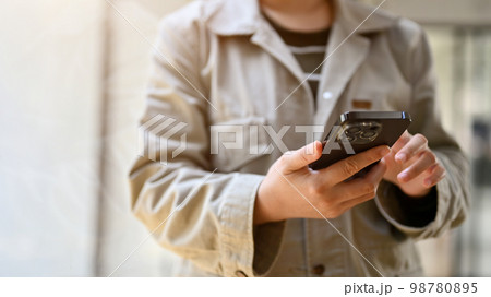 A hipster female freelancer using her mobile phone, chatting, reading email, using mobile app A hipster female freelancer using her mobile phone, chatting, reading email, using mobile app 98780895