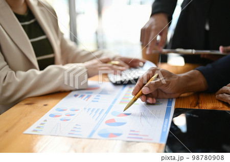 Professional Asian male financial analyst pointing his pen on financial report, analyzing data 98780908
