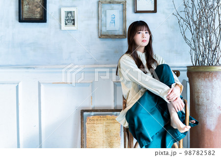 椅子に座るオシャレな若い女性 98782582