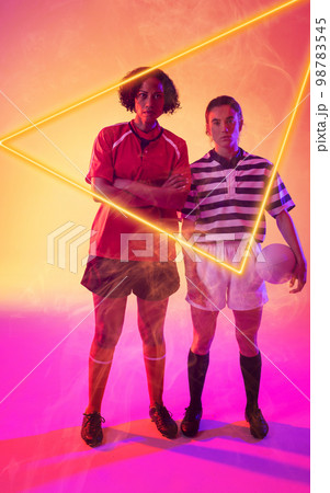 Illuminated triangle over multiracial female rugby players standing over abstract background 98783545