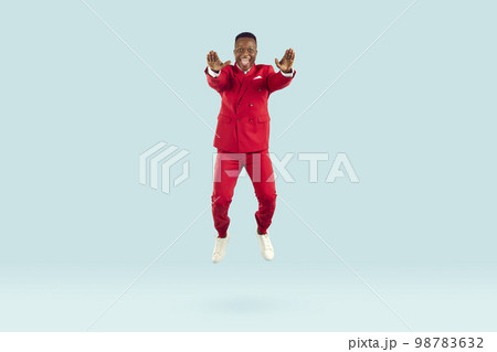 Funny stylish african american man having fun bouncing on pastel light blue background. Funny stylish african american man having fun bouncing on pastel light blue background. 98783632