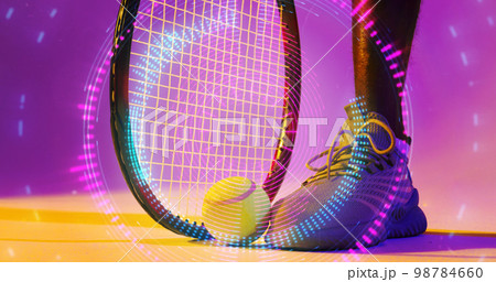 Low section of african american male tennis player with racket and ball over circular pattern Low section of african american male tennis player with racket and ball over circular pattern 98784660