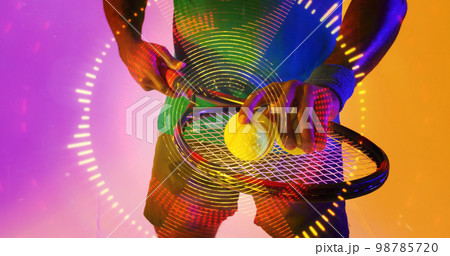 Midsection of african american male tennis player with racket and ball over circular pattern Midsection of african american male tennis player with racket and ball over circular pattern 98785720