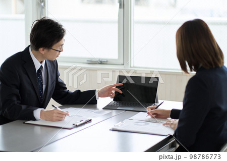 パソコンを使ってミーティングをするアジア人ビジネスパーソン パソコンを使ってミーティングをするアジア人ビジネスパーソン 98786773