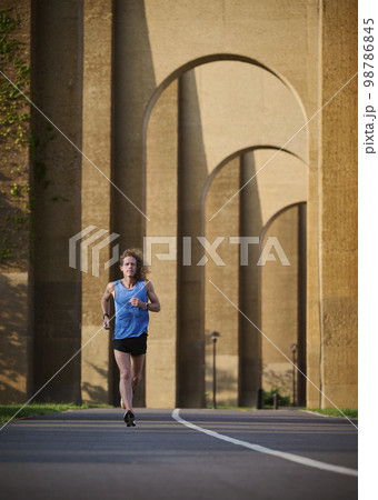 Man jogging under bridge 98786845