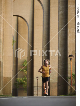 Man jogging under bridge 98786855