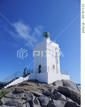 South Africa, Western Cape, St Helena, Woman climbing white lighthouse on sea coast 98787135